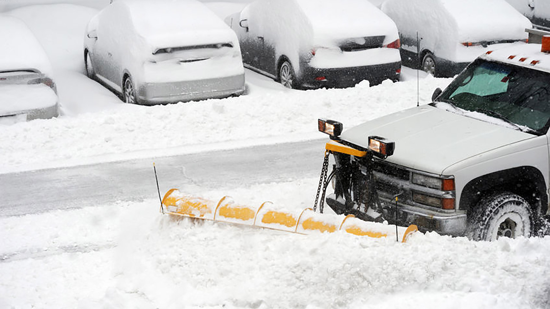 Commercial snow plow truck in a parking lot in Lansing, MI.