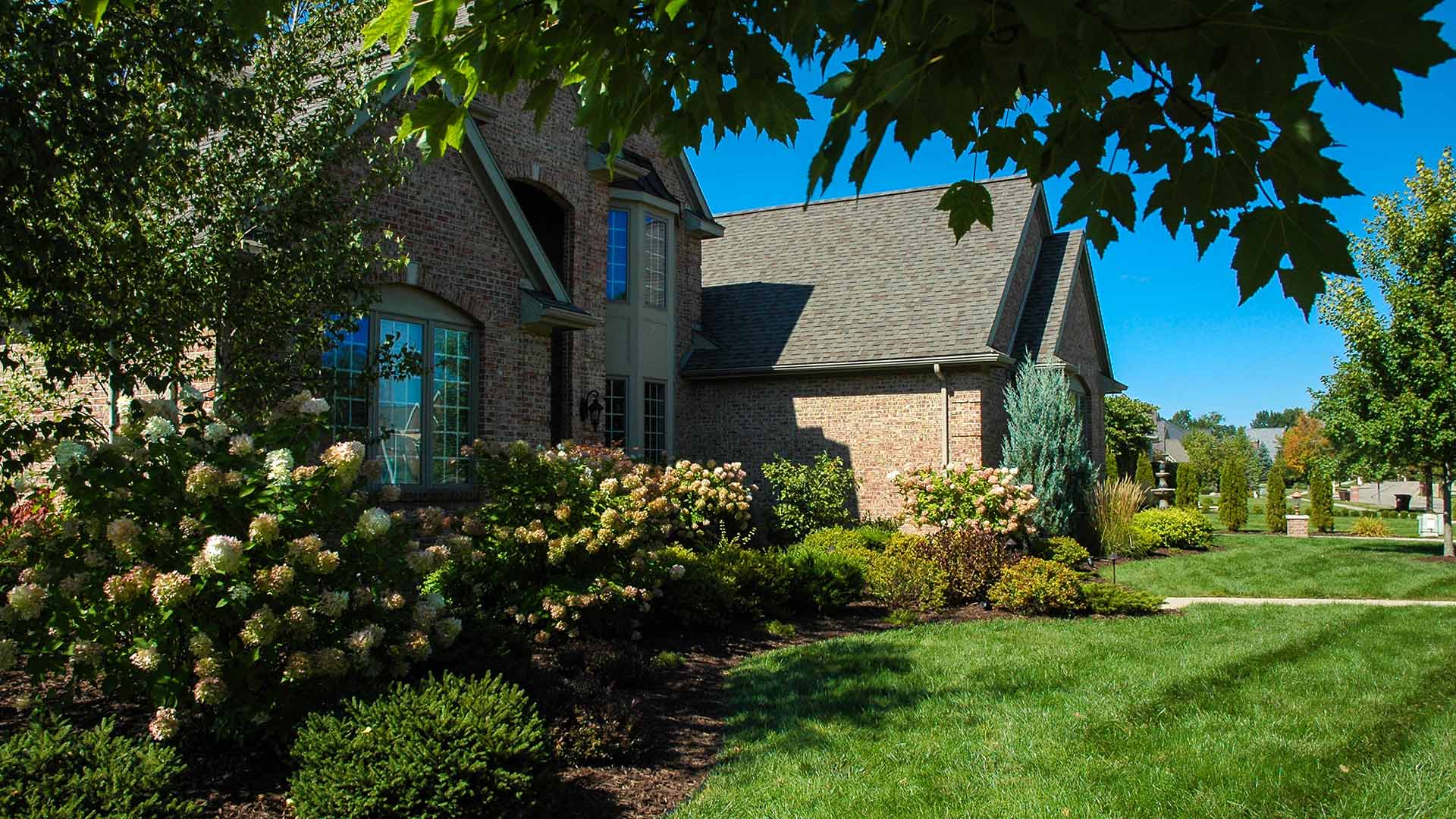 Maintained lawn and landscape bed in Haslett, MI.