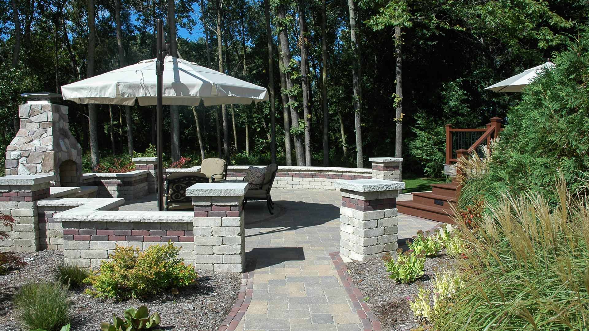 An outdoor fireplace with a walkway added to a patio installed in Lansing, MI.