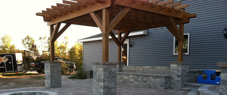 A pergola installed on a patio beside a fire pit in Williamston, MI.