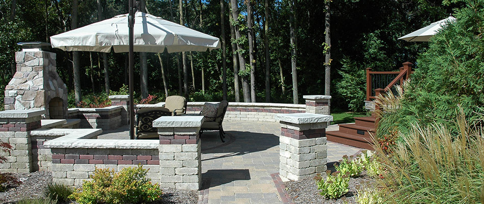 A seating wall installed with a patio and an outdoor fireplace in Haslett, MI.