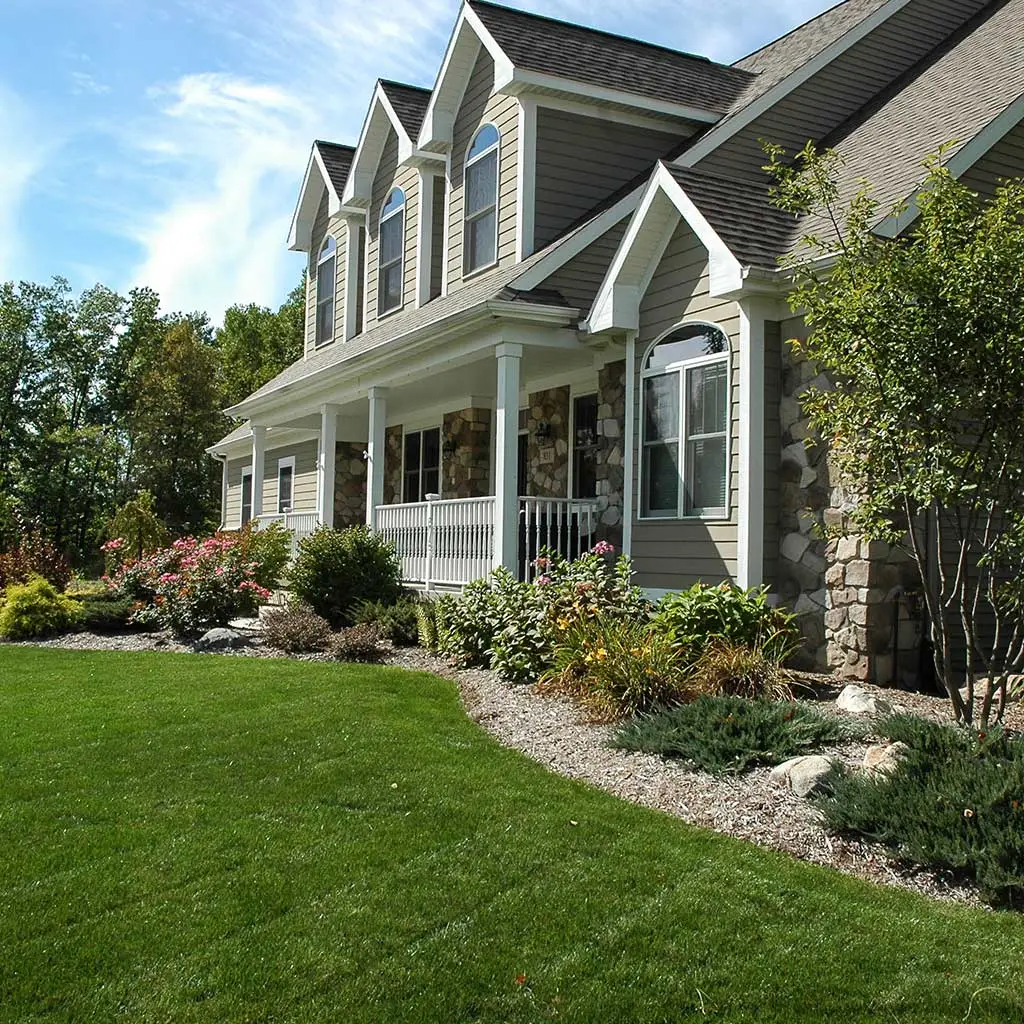 Home with maintained lawn and landscape in Watertown Township, MI.