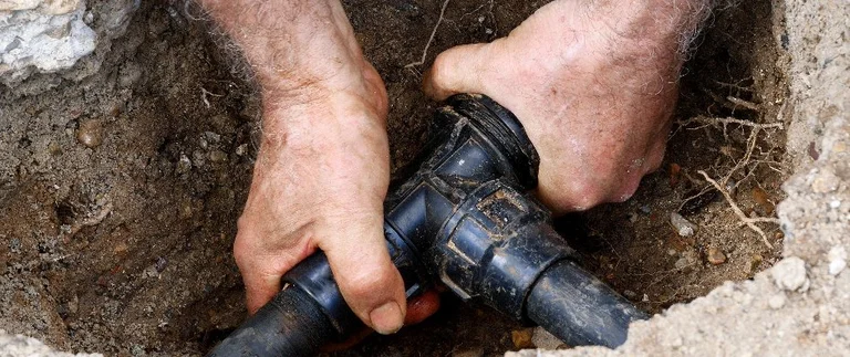 content-worker-fixing-pipes-of-irrigation-system
